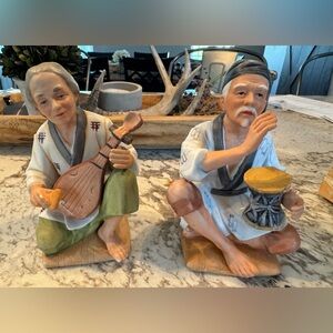 Vintage porcelain figurine of an Asian man playing biwa and 1 playing a drum.